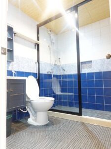 洗面台、小物棚、トイレ、シャワーが備えられたバスルーム
