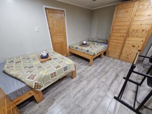 向い合ったベッドと木製クローゼットが設置されたデラックスルーム