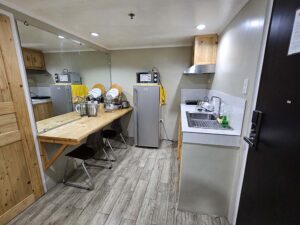 シンク、冷蔵庫、電子レンジ、調理器具が揃ったキッチン
