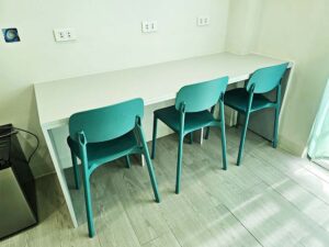 3人用の机と椅子、壁面に取り付けられた3つのコンセント