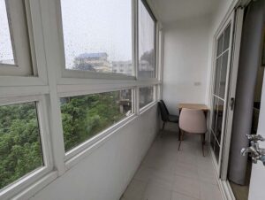 大きな窓に囲まれた屋内型バルコニーと小さなテーブルセット