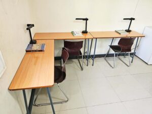 部屋の角にL字に配置された、3台のデスクライト付き勉強机