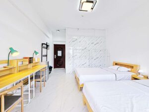 ベッド、勉強机、冷蔵庫、ハンガーラックが備わった2人部屋