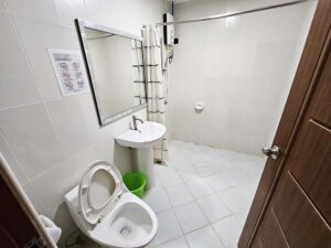 トイレ、洗面台、温水器付きシャワーが備わったバスルーム