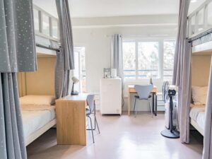 カーテン付き二段ベッドが向かい合って設置されたクアッドルーム