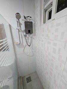 温水器の隣にあるシャワーヘッドとソープホルダー