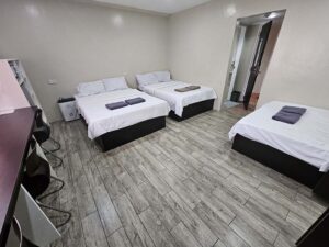 3台のベッドと長い勉強机、除湿器が設置された3人部屋