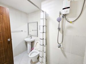 カーテンで仕切られたシャワーとトイレのあるバスルーム