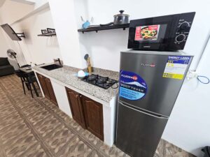 冷蔵庫、レンジ、コンロ、シンク、調理器具を備えたキッチン