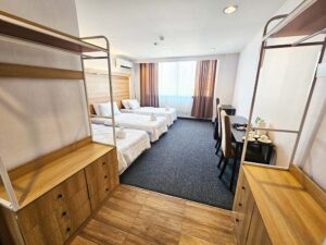 向い合った2台のワードローブと3台の机が配置された3人部屋