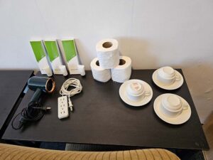 机の上に置かれたドライヤー、延長コード、3客のコーヒーカップ