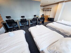 ベッドの向かい側に4台の勉強机とオフィスチェアが並んだ4人部屋