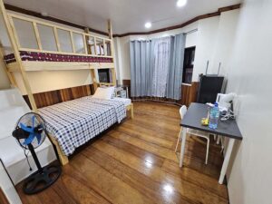 二段ベッド、テーブルと椅子、冷蔵庫が備わったセミシングルルーム