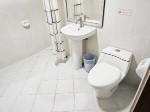 トイレ、洗面台、ごみ箱が設置されたバスルーム
