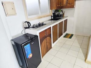 冷蔵庫、電気ケトル、コンロ、シンク、調理器具のあるキッチン