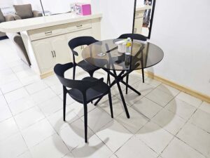 丸いガラステーブルと椅子、カウンターの上に置かれた2台の金庫