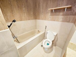 バスタブとシャワー、トイレ、小物棚が備わったバスルーム