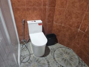 トイレとごみ箱が設置されたタイル張りの共用トイレエリア