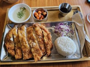 とんかつとキャベツ、ご飯、スープ、キムチが盛られたトレイ