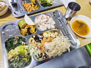 炒飯、フライドチキン、バジルポーク、焼売、パスタ、野菜炒めが並ぶ昼食