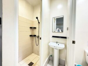 壁と扉で仕切られたシャワールーム、洗面台、トイレットルーム