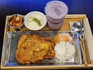 チキンカツとご飯、キムチ、スープ、スムージーがのった木製トレイ