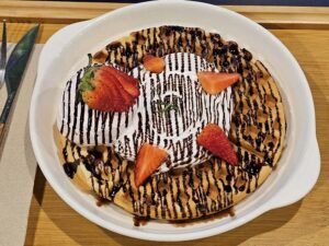 イチゴと生クリーム、チョコソースで飾られたワッフル