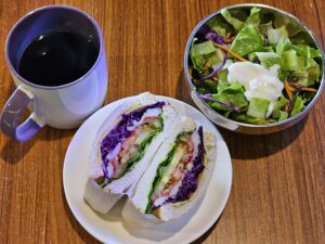 クラブサンドイッチとサラダ、ホットコーヒーが並ぶ朝食