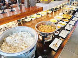 ご飯、炒飯、副菜、グラタンが並ぶ昼食のビュッフェカウンター