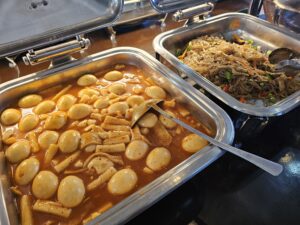 トレイに盛られた韓国料理のゆで卵入りトッポキとチャプチェ