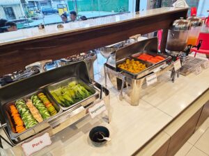 生野菜、茹でたチンゲン菜とかぼちゃ、パパイヤが並んだ夕食ビュッフェ