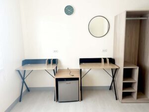 2台の勉強机、冷蔵庫、ワードローブが備えられた2人部屋