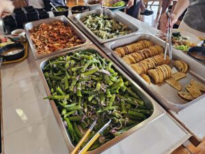 ビュッフェテーブルに並ぶオクラ、キムチ、揚げ物、野菜炒め