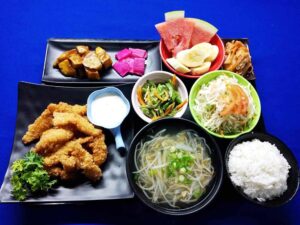 揚げ物、もやしのスープ、ご飯、サラダ、バナナが盛られた食事