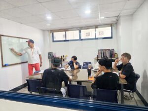白板を使ってグループ授業を行う講師と、参加している5人の生徒