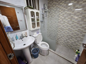 洗浄便座付きトイレと小物棚のある共用バスルーム
