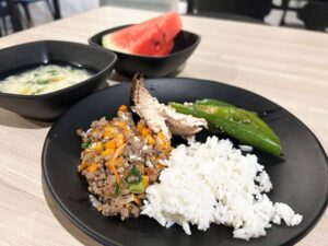ご飯と白身魚、そぼろ炒めが盛られた皿に、スープとスイカが付いた食事