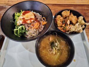 ビビンバと韓国風味噌スープ、キムチや揚げ物が添えられた夕食