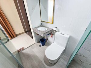 シャワーエリアと仕切られた、トイレと洗面台のあるバスルーム