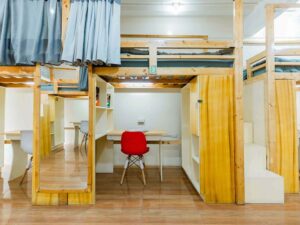 カーテンの付いた上段のベッド、下段の勉強机と収納スペース