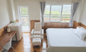 バルコニーに面した窓とクイーンサイズベッドがあるシングルルーム
