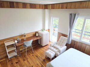 リクライニングチェア、机、冷蔵庫、電気ケトルが備わった室内