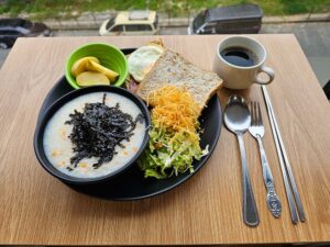 お粥、トースト、ハムエッグ、サラダとリンゴ、コーヒーの朝食