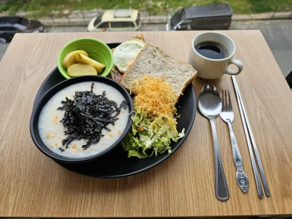 お粥、トースト、ハムエッグ、サラダとリンゴ、コーヒーの朝食