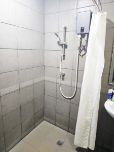 カーテンで仕切られた温水器付きシャワーエリア