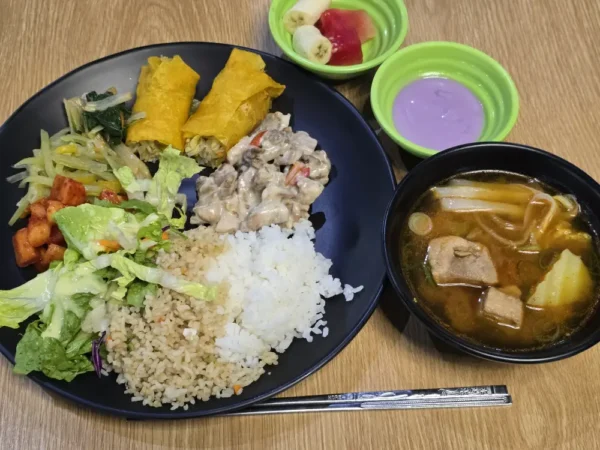 野菜炒め、ルンピア、豚肉のクリーム煮、豚肉スープ、ウベヨーグルトが並ぶ昼食