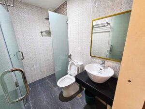 洗面台、トイレ、シャワーを備えたタイル張りのバスルーム