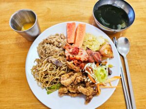 サラダ、鶏の唐揚げ、焼きそば、パパイヤ、わかめスープの昼食