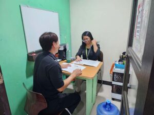 スピーキングのマンツーマン体験授業で笑顔で会話する学生と講師