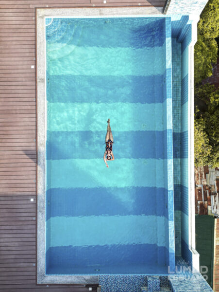 俯瞰で見た屋外インフィニティプールと水面に浮かぶ女性
